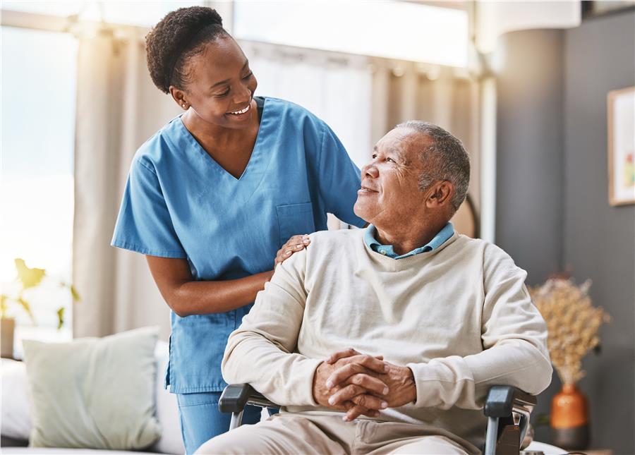Nurse supporting an older man using a wheelchair